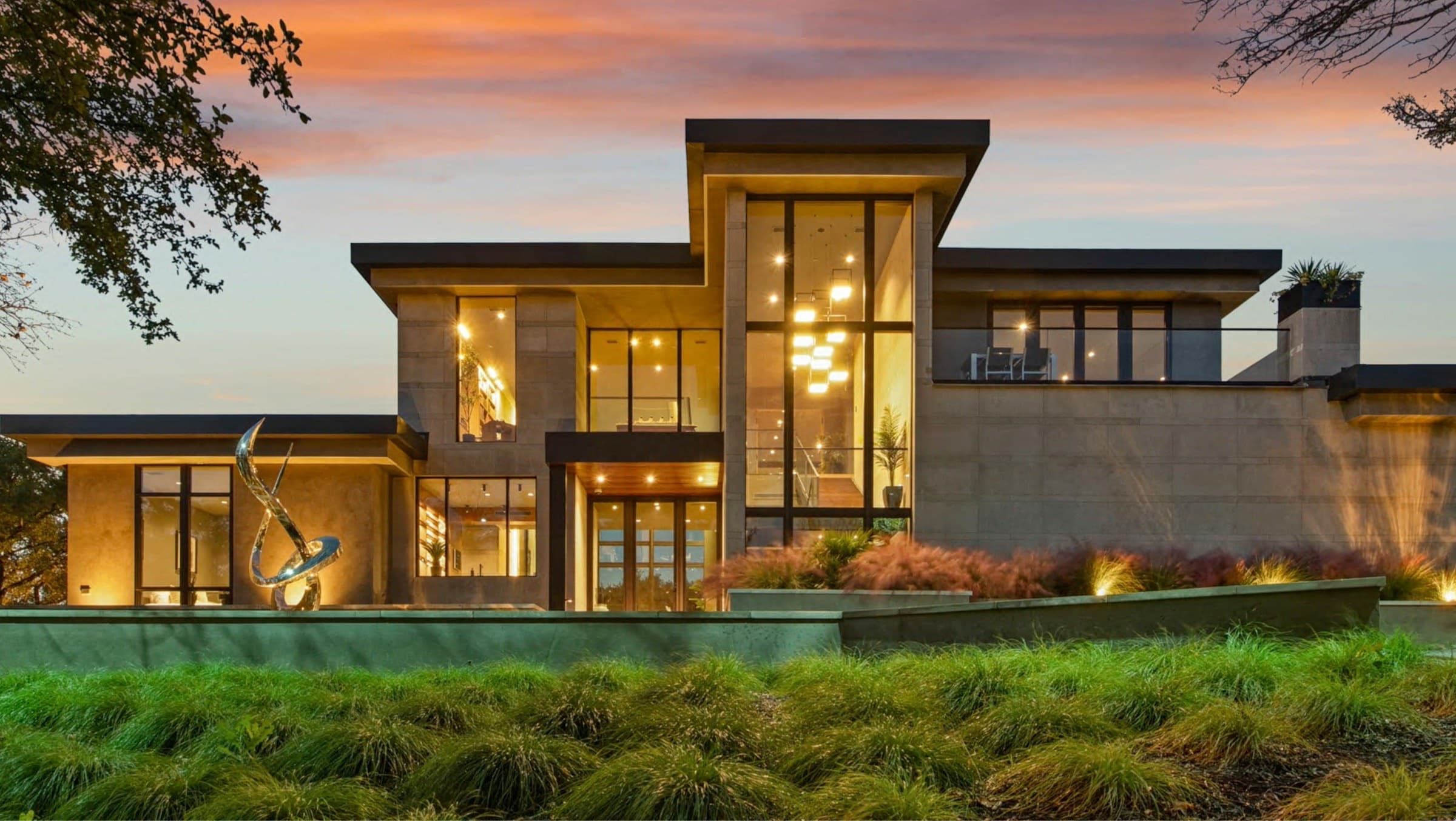 A modern Southern California home glowing at dusk